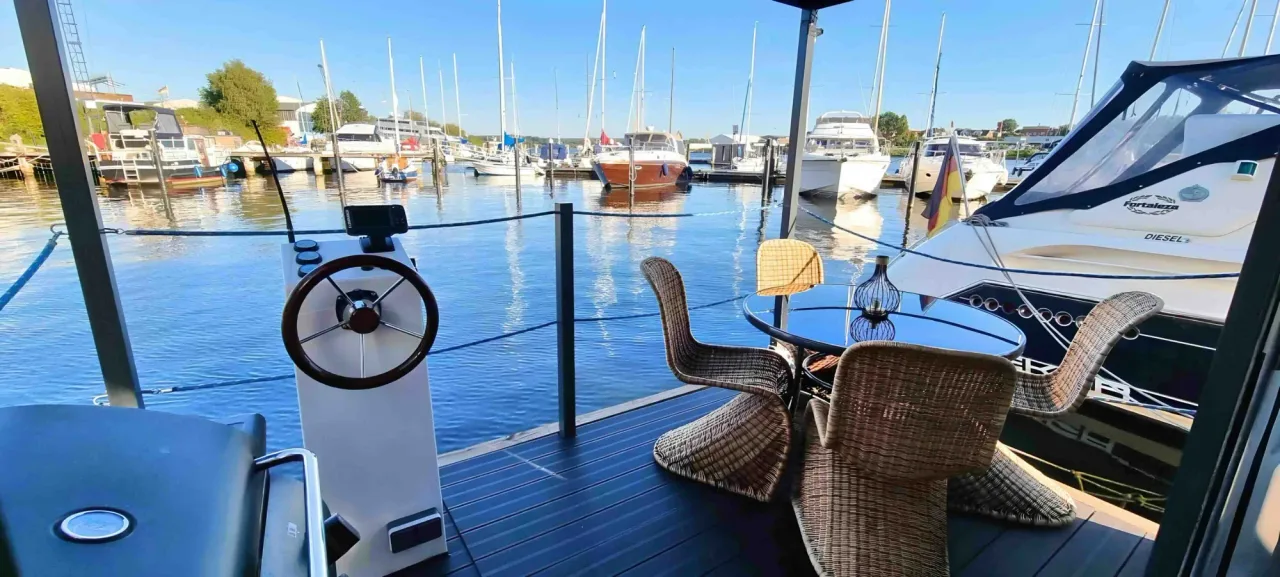 Sonnige Frontterrasse des Hausboots AHOY Masal mit Blick über die Travemarina in Lübeck